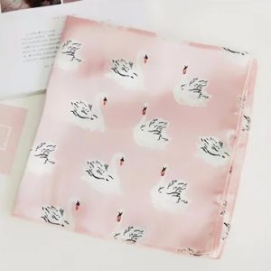 Découvrez l'élégance intemporelle avec le Foulard Rose Elisabeth, où la grâce du cygne se mêle à la douceur d'un fond rose.